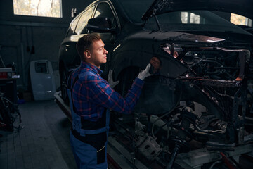 Wall Mural - Young man installing fender on vehicle frame