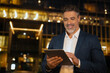 © Stock 4 You - Hispanic successful mature adult professional business man in formal suit working on pc computer. Indian senior businessman holding digital tablet using application at office in evening, copy space