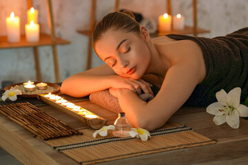 Wall Mural - Beautiful young woman relaxing in dark spa salon, closeup