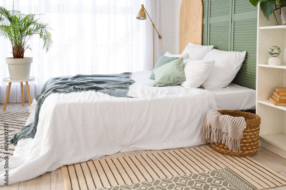 Interior of light bedroom with bed and lamp