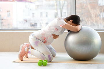 Poster - Beautiful young pregnant woman training with fitball near window at home