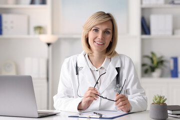 Poster - Smiling doctor with laptop having online consultation at table in office