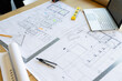 © Wavebreak Media - Architectural blueprints and drafting tools are on wooden table