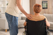 © Pixel-Shot - Mature woman in wheelchair with her husband at home, back view