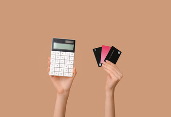 Sticker - Female hands with credit cards and calculator on brown background