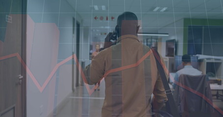 Wall Mural - Image of graphs, grid pattern, african american man talking on cellphone while walking in office