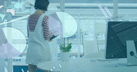Poster - Biracial woman in stripes views data charts on a large screen in a modern office