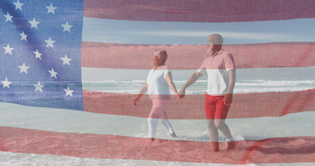 Canvas Print - Diverse couple holding hands, walking on beach with blue background