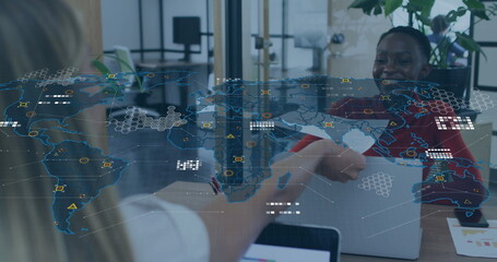 Poster - Image of world map over caucasian woman passing a document to african american woman