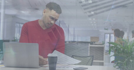 Poster - Young biracial colleague with short curly hair and beard, in red sweater, studying papers
