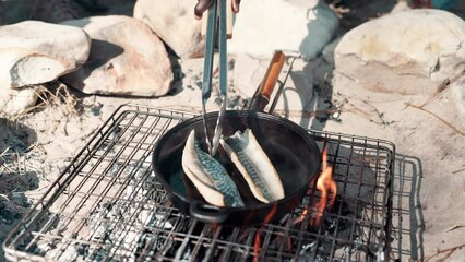 Poster - Camp, hand and cooking with pot on fire for fish breakfast, hungry or nutrition meal in nature. Travel, campsite and person with utensil for fishing trip, weekend break or summer adventure in forest