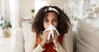 © peopleimages.com - Sick girl, sofa and blowing nose with tissue for virus, infection or congestion in living room at home. Young female person, child or kid with cold, flu or sinus in fatigue, fever or sneeze at house