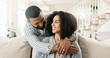 © peopleimages.com - Couple, love and hug or relax on sofa for date night or weekend break, romance and happiness with embrace or commitment. Man, woman and bonding on couch in new apartment or home, affection and care.
