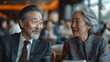 © Haider - young Chinese businessman and an elderly businesswoman at an airport lounge discussing business matters with digital devices on the table in formal attire