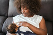 © Cavan Images - African woman is breastfeeding a baby on a couch