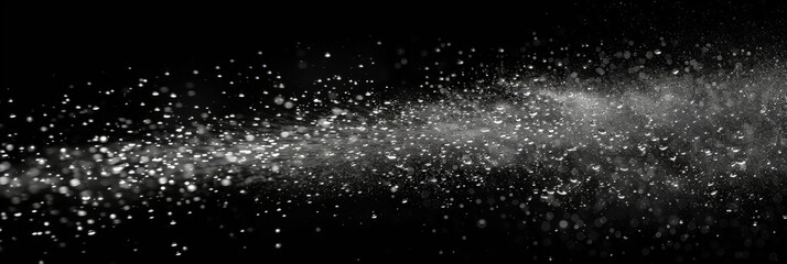 Wall Mural - Water spray on black background, white water droplets falling in the air, particles of dust floating in space.Abstract black and white bokeh lights with sparkling particles creating a dramatic