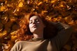 © alisaaa - redhead woman sleeping on autumn leaves at park