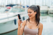 © luismolinero - Young pretty woman using mobile phone at outdoors with sad expression