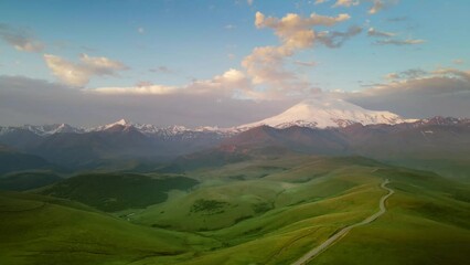 Wall Mural - Elbrus mountain with clouds at sunrise. Aerial drone view. Gil-Su valley in North Caucasus, Russia. Summer landscape. 