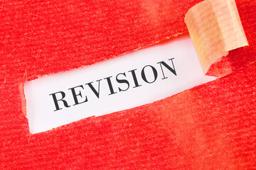 Sticker - REVISION word written under the torn paper on a white background