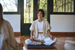 © insta_photos - Young happy smiling Hispanic woman yoga coach training group class yoga meditation session sitting in yoga pose in studio talking to people during retreat mind body health therapy.