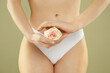 © New Africa - Gynecology. Woman in underwear with rose flower on green background, closeup