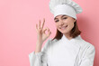 © New Africa - Professional chef showing OK gesture on pink background. Space for text