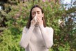 © New Africa - Woman with napkin suffering from seasonal allergy outdoors