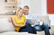 © peopleimages.com - Couple, read and tablet on sofa for social media, scroll and news report online on couch. Technology, internet and app on digital website in home, man and woman people in lounge with touchscreen