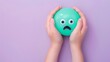 © Nasreen - Hands holding a shocked emoji on a pastel purple background with ample space for text The emoji is bright green with wide eyes and an open mouth