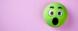 © Nasreen - shocked emoji on a pastel purple background with ample space for text The emoji is bright green with wide eyes and an open mouth