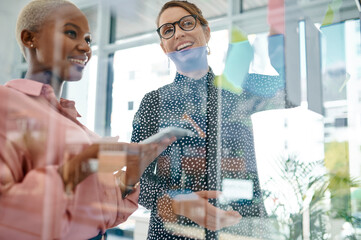 Poster - Women, happy or brainstorming solution on glass wall, paper and sticky note for planning or teamwork in office. Creative project, tablet and designer in startup for ideas or storyboard with schedule