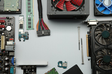 Poster - Frame of graphics card and other computer hardware on light background, flat lay. Space for text