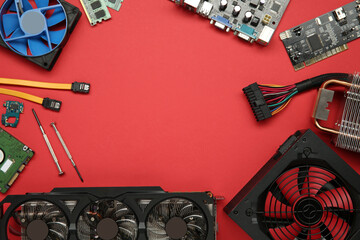 Poster - Frame of graphics card and other computer hardware on red background, flat lay. Space for text