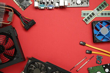 Poster - Frame of graphics card and other computer hardware on red background, flat lay. Space for text