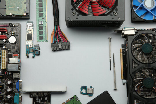 Frame of graphics card and other computer hardware on light background, flat lay. Space for text