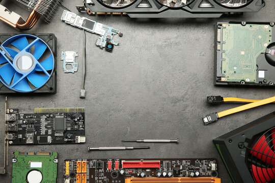 Frame of graphics card and other computer hardware on grey textured table, flat lay. Space for text