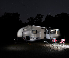 Wall Mural - forest silhouetted by stars with camping trailer