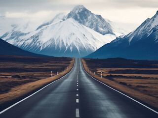 Wall Mural - A deserted highway leads the way to towering snow-covered peaks