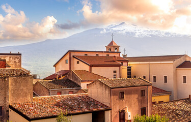 scenic view from a beautiful italian town to amazing buildings with church and roofs and picturesque highland mountain with nice blue cloudy sky on background