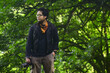 © Harris Kharisma - a man exploring nature poses against the background of trees in the forest