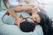 © peopleimages.com - Passion, affection and couple in bedroom with kiss, romance and morning bonding in apartment. Relationship, man and woman in bed with intimate embrace, love and relax with care on weekend in home