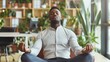 © mattegg - Stress Relief Concept: Black Businessman Meditating at Workplace
