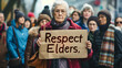© mittpro - An elderly woman holding a sign that reads 'Respect Our Elders,' standing proudly with a diverse group of supporters behind her