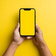© AliRaza - Mock-Up Empty Yellow Mobile Screen, Close-Up of Man Holding Smartphone with Blank Screen on Yellow Background,