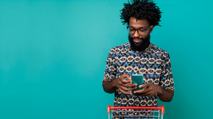 Wall Mural - Afro black man with a shopping cart and a phone in his hands, makes purchases online, background blue on plain green background