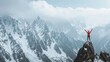 © Ibad - Panoramic image of climber standing with arms raised in the air on mountain top in front of majestic scenery