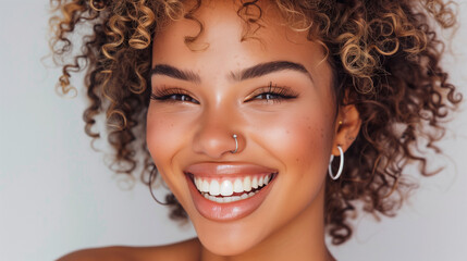 Portrait of a beautiful smiling woman with afro hair, nose ring, and ear piercings, wearing earrings. The photo features a white background, professional photography, professional color grading, soft 
