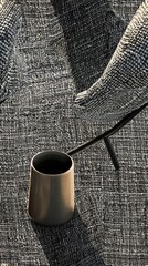 Wall Mural - A black vase sits on a rug with a chair behind it