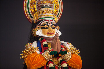 kathakali dancer in yellow facial makeup depicting subhramanya god